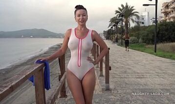 Нудистка гуляет по улице в прозрачном купальнике